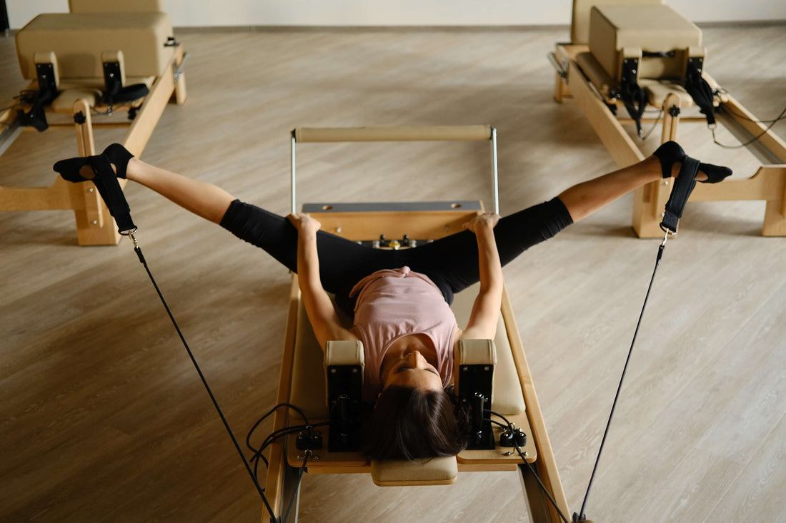 Pilates@home using a home reformer: feet pulling straps
